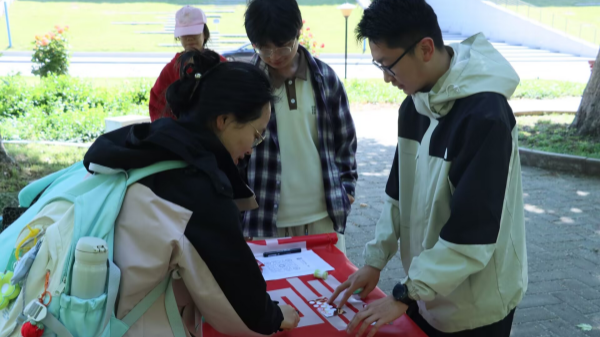 图为在“红色拼图”摊位,员工通过复原历史图片重温五四峥嵘岁月_副本.png